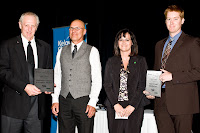 Four people holding award plaques on stage at the 2008 Business Excellence Awards