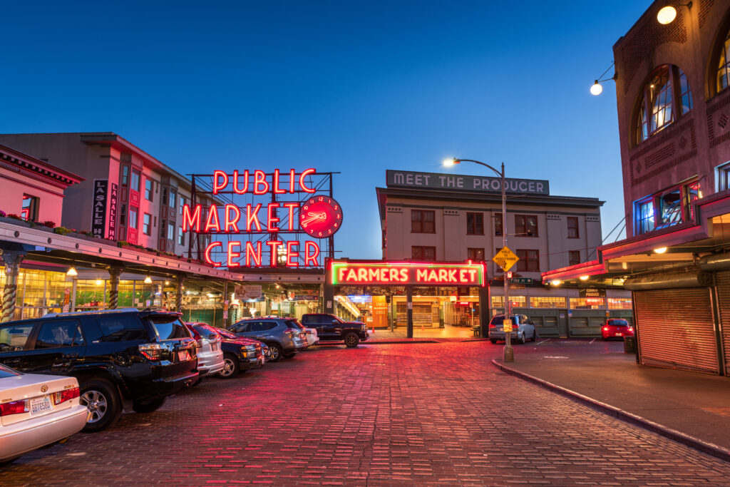 Pike Place Public Market sign and street lit up at dusk