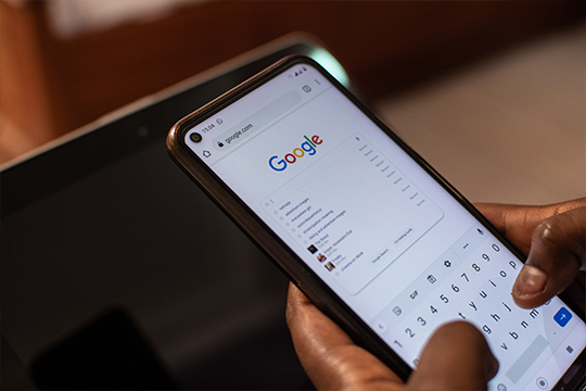 Person typing a search into Google on a smartphone