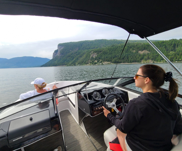 Jocelyn driving a boat on a lake