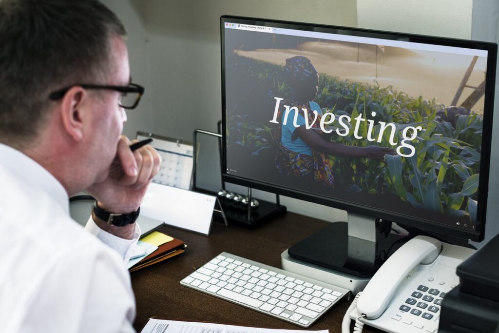 Advisor at a desk studying a computer screen headed Investing for Capstone Asset Management