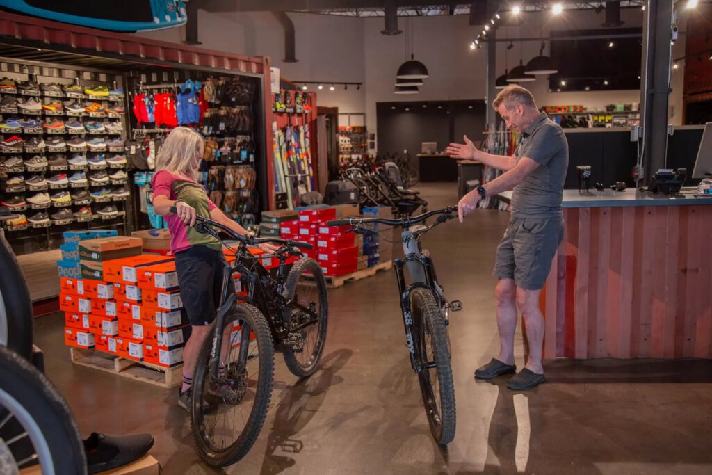 Two staff with mountain bikes inside the Fresh Air bike and outdoor store
