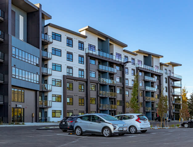 Modern multi-storey Highstreet Ventures apartment building with cars parked out front