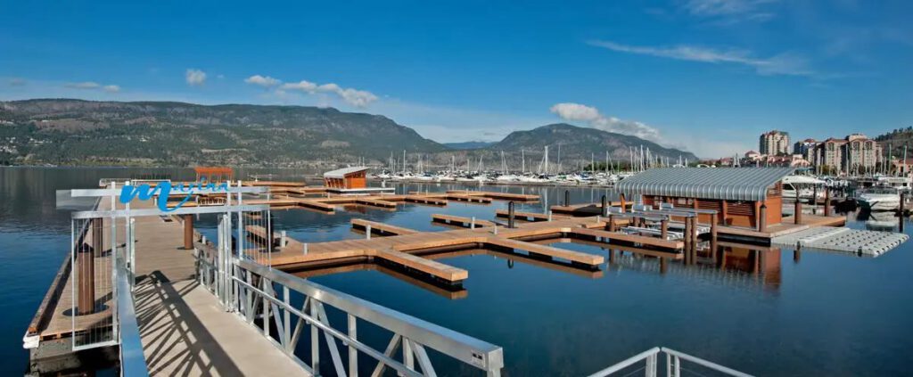 Docks and boat slips at Kelowna Downtown Marina with hills across the lake