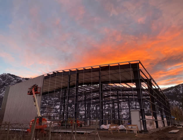 Steel frame of a Metal Structure Concepts building under construction at sunset