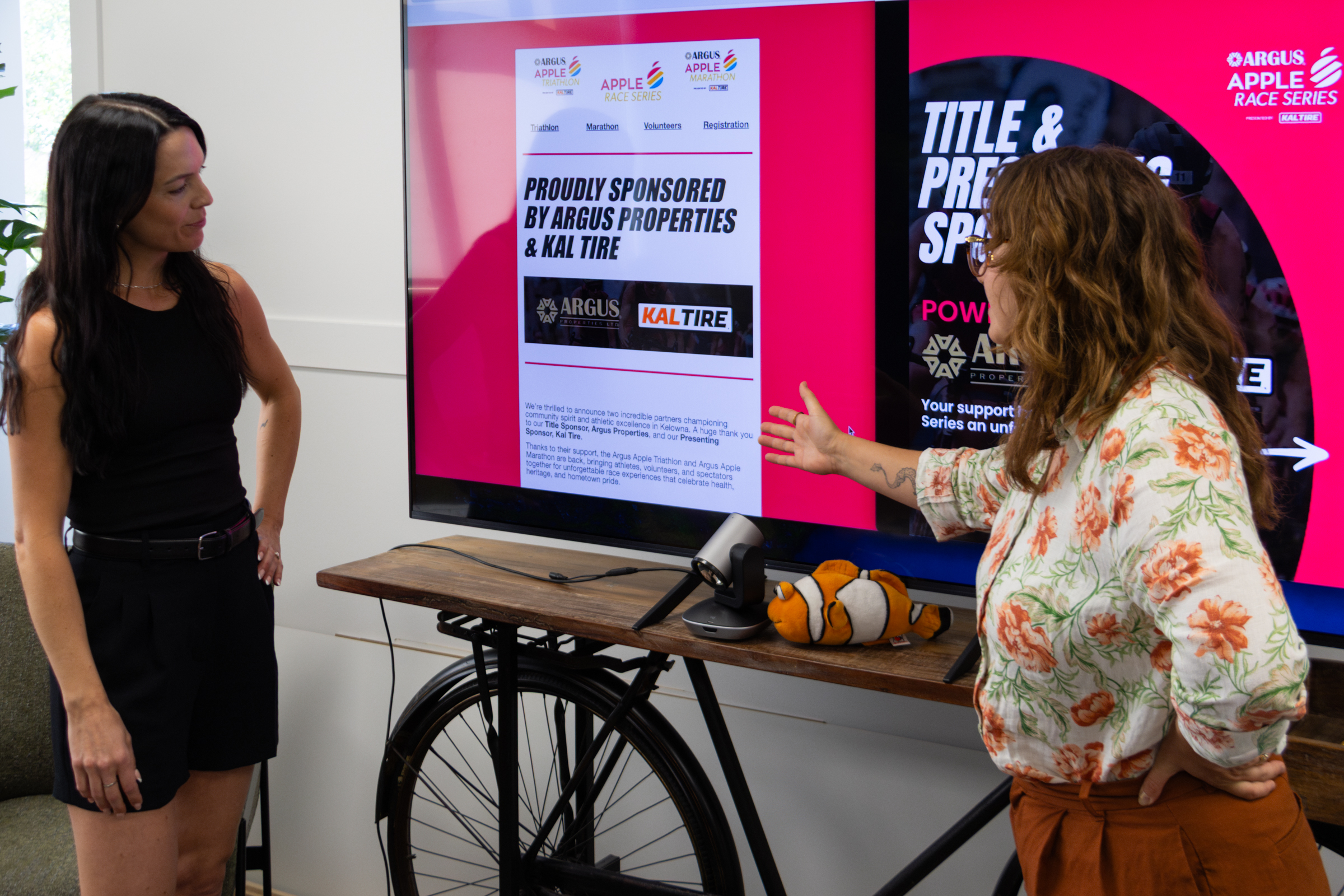 Two team members at a community event with a newsletter sign-up
