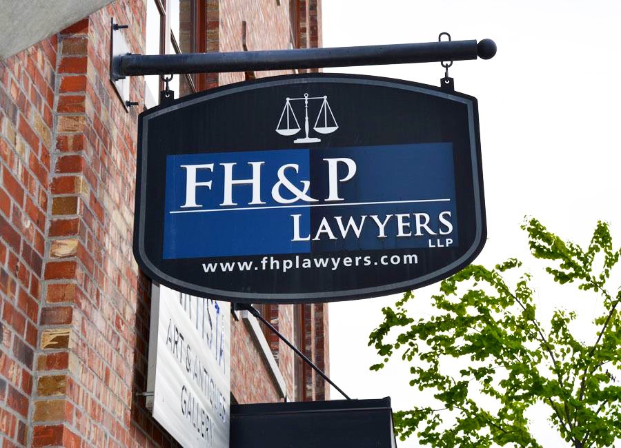 FH&P Lawyers LLP hanging sign with website address on a brick building
