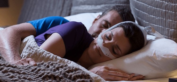 Couple sleeping peacefully in bed for Snore MD