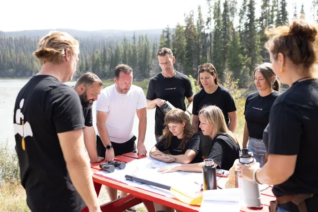 The team planning around a map on a picnic table